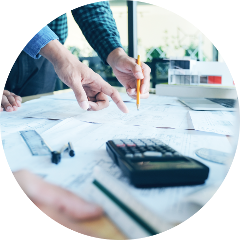 Equipo de negocios analizando proyectos y cálculos en una oficina, con enfoque en planificación estratégica